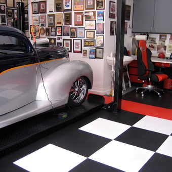 Custom garage with car lift, checkered floor, and wall art - Ira from Upland, CA