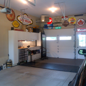 Organized garage with cabinets, tool chest, and vintage signs - Pete's Garage from London, Ontario