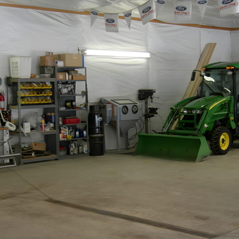 Organized garage with tractor, storage shelves, and workbench - ScodeMike from Monument, Colorado