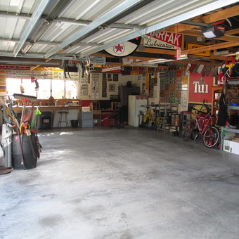 Organized garage with workbenches, tool storage, and wall decor - Andy McDougall from Christchurch