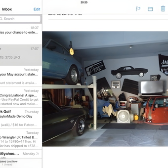 Organized garage with car lift, wall art, and motorcycles - Sam from Olathe, Ks