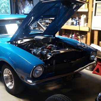 Classic blue muscle car with open hood in garage - Jim from Sharon, Wi