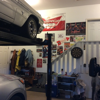 Organized garage with car lift, wall decor, and workbench - Nedle from Carstairs, AB