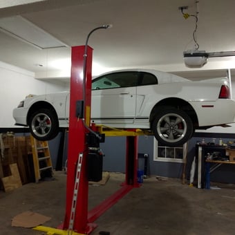 Two-post car lift with white Mustang in garage - Jeff from Fort Valley, GA