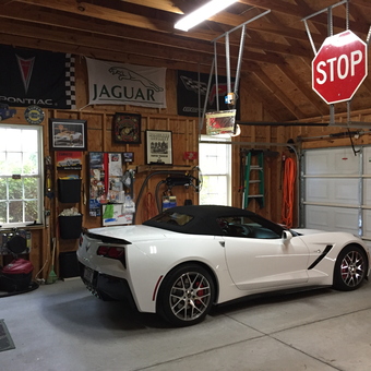 Organized garage with Corvette, banners, and stop sign decor - Keith G from Camden, SC