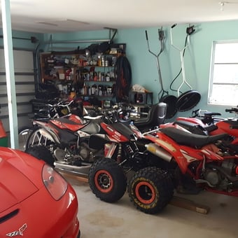 Organized garage with red ATVs, Corvette, and shelving - Salmann from Port Charlotte, FL
