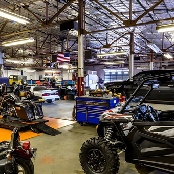 Motorcycle Lifts, Tool Chests, and ATV in Busy Garage - F/X Motor Sports from Amarillo, TX