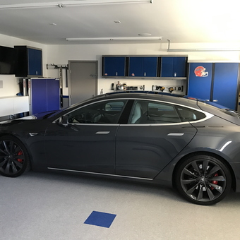 Modern Garage With Blue Cabinets and Tesla - Freewill