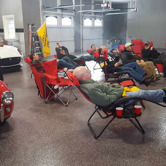 Garage Lounge with Classic Cars and Reclining Chairs - Anonymous