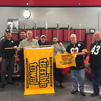 Steelers Fans in Garage with Red Cars and Cabinets - Anonymous
