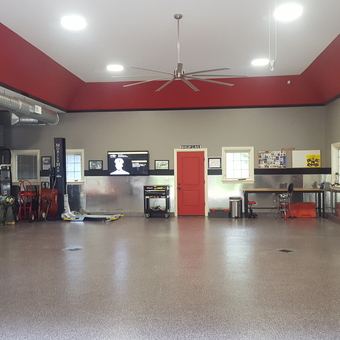 Spacious Garage with Red Cabinets and Car Lift - Anonymous