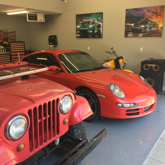 Organized garage with red cars, tool chests, and wall art - Gene from Indianapolis, IN