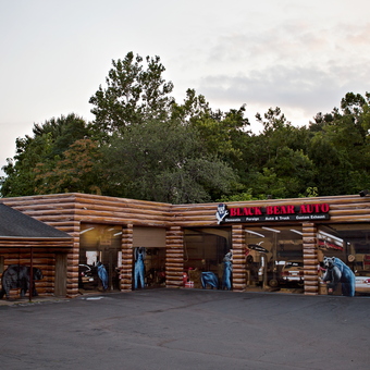 Log cabin style auto garage exterior with murals - Black Bear Auto from Bristol, CT