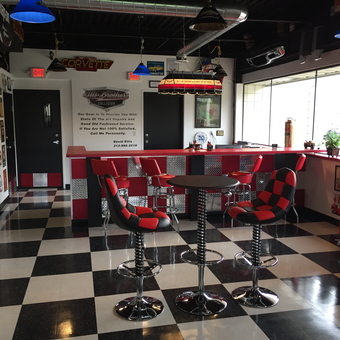 Retro Garage Lounge with Checkerboard Stools and Decor - Ellis Brothers Collision from Milford, MI