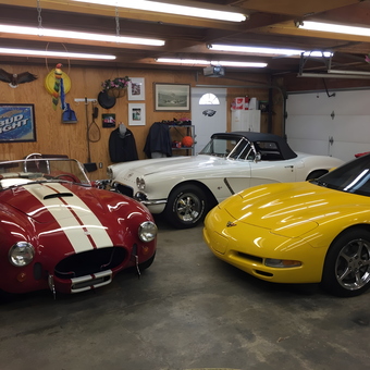 Classic and Modern Sports Cars in Well-Organized Garage - Anonymous