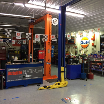 Organized garage with car lift, tool chests, and Gulf signs - Kenny's Garage from Milton, Del
