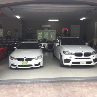 Organized Garage with BMWs, Wall Signs, and Storage - Anonymous