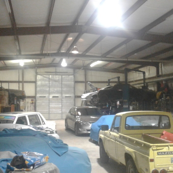 Spacious garage with car lift, covered vehicles, and storage - Gearheadgarage from Dripping Springs, TX