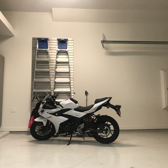 Modern garage with motorcycle, cabinets, and wall storage - Jante from Bellaire, Texas
