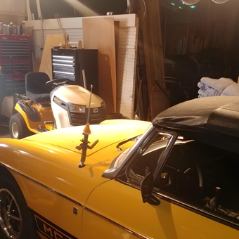 Organized garage with tool chests, mower, and yellow car - Polly from Swanton, OH