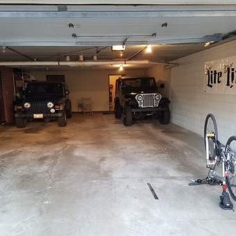 Spacious garage with Jeeps, bike repair stand, and wall decor - Matthew Krzesniak from Palos Hills, ILLINOIS