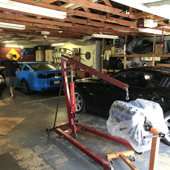 Organized garage with cars, engine hoist, and storage shelves - Dongview Garage from Hilliard, Oh