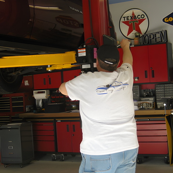 Garage with Car Lift, Red Cabinets, and Wall Signs - Perry from Woodbury, NY