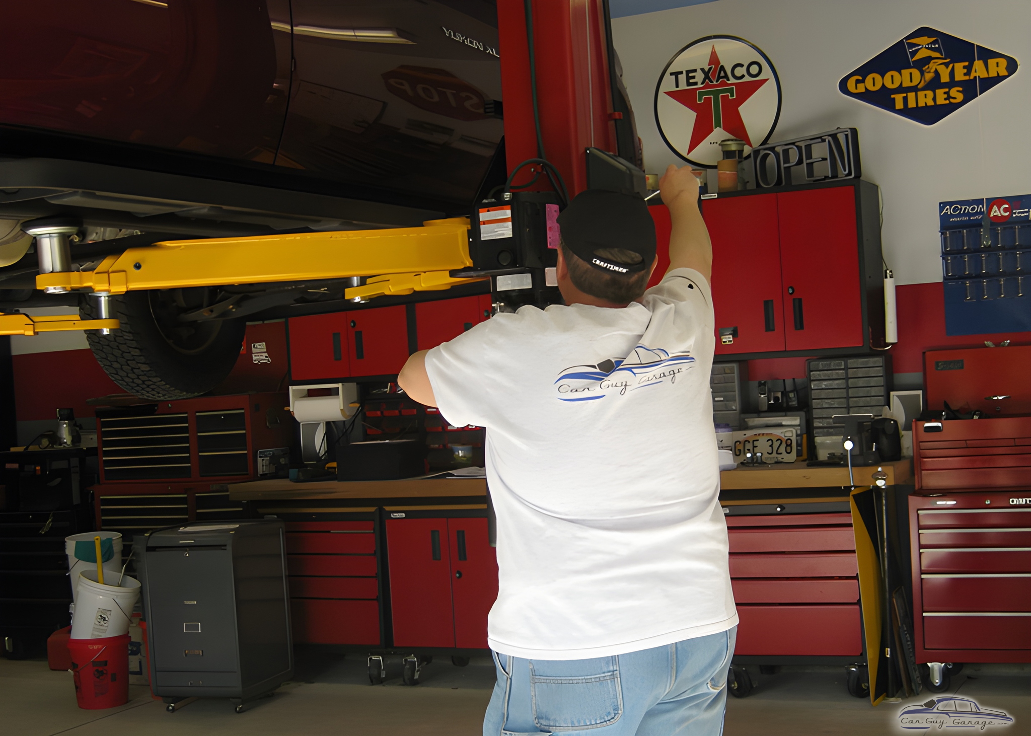Garage with Car Lift, Red Cabinets, and Wall Signs - Perry from Woodbury, NY