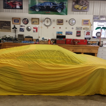Organized garage with yellow car cover and wall decor - Mike from Fargo, ND