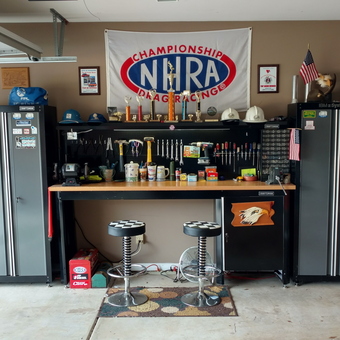 Organized garage with tool cabinets, workbench, stools, and decor - Scotty Mack from Columbus, GA