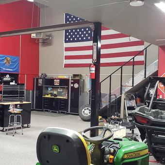 Red garage with car lift, tool cabinets, and vehicles - Khris from Broken Arrow, OK