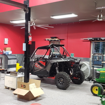 Red garage with vehicle lift, tool cabinets, and decor - Khris from Broken Arrow, OK