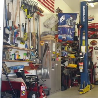 Organized garage with tools, lawn equipment, and car lift - GATOR from SPRINGFIELD, NJ
