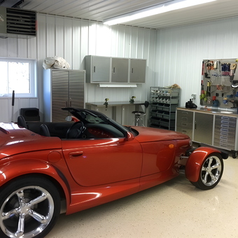 Organized garage with red roadster and metal cabinets - Roger from Falconer, NY