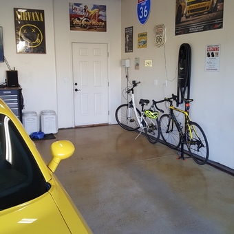 Organized garage with yellow car, bikes, and wall signs - Jeffrey from Cheyenne, WY