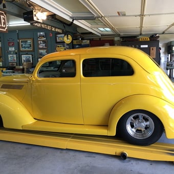 Classic yellow hot rod on lift in decorated garage - HOTTAXI from Ventura, CA