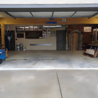 Organized garage with wall art, punching bag, and workbenches - ci-19400