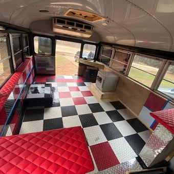 Custom Bus Garage With Checkered Flooring and Red Diamond Benches - William