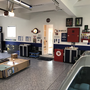 Organized garage with cabinets, wall decor, and Texaco bin - Phil