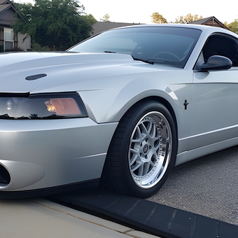 Silver Ford Mustang with Custom Wheels Parked in Driveway