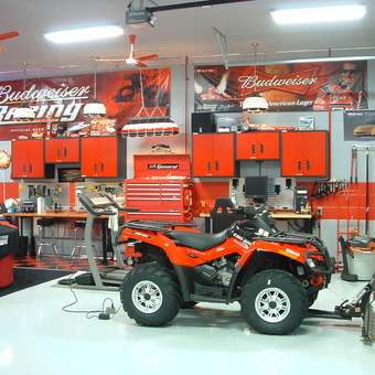 Organized garage with red cabinets, tool chests, and ATV - 2008 Vette