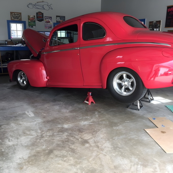 Classic red coupe on jack stands in organized garage - Curti from Rapid City, SD