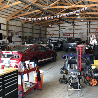 Organized garage with red Mustang, tool carts, and work stools - Jim from Great Bed, KS
