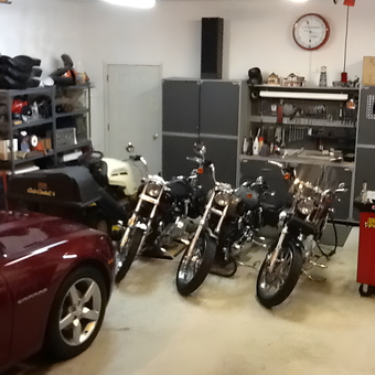 Organized garage with motorcycles, cabinets, and shelving - Mac's Garage from Thompson, CT