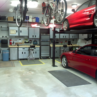 Organized garage with car lift, storage cabinets, and workbench - John from St. Charles, MO