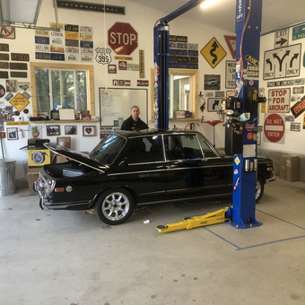Classic car on lift with vintage signs - Chris from Hauser, ID