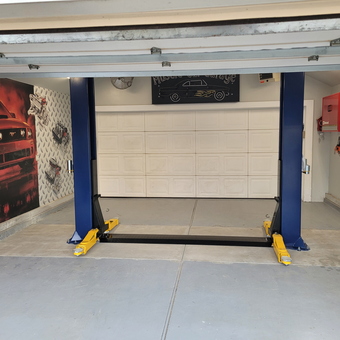 Clean garage with two-post car lift and wall art - Steve from Oceanside, NY