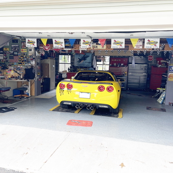 Organized garage with yellow Corvette and tool storage - John from Chicopee