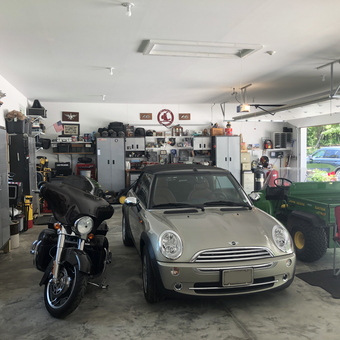 Organized garage with cabinets, motorcycle, and Mini Cooper - Butch from St. Clair, MO
