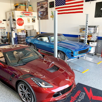 Organized garage with car lift, classic cars, and wall decor - Dave from Mesa, AZ